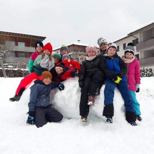 Kinder sitzen auf Schneekugeln