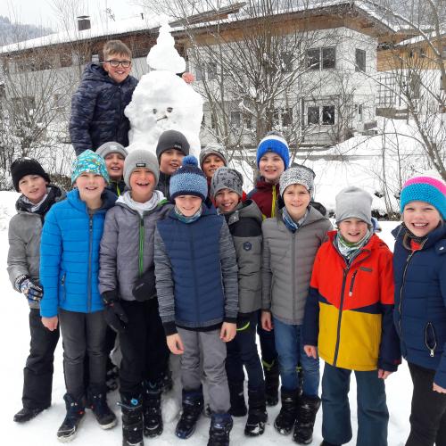 Kinder rund um einen Schneemann
