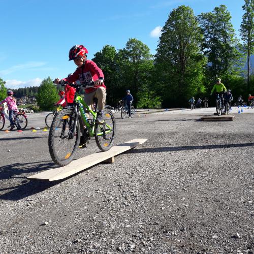 Kinder fährt mit Fahrrad über eine Wippe