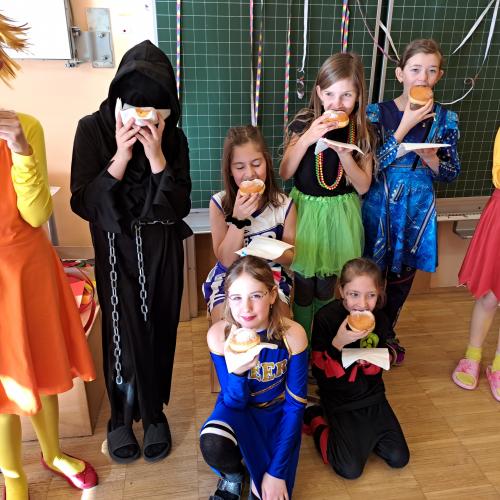 verkleidete Kinder beim Faschingkrapfen-Essen