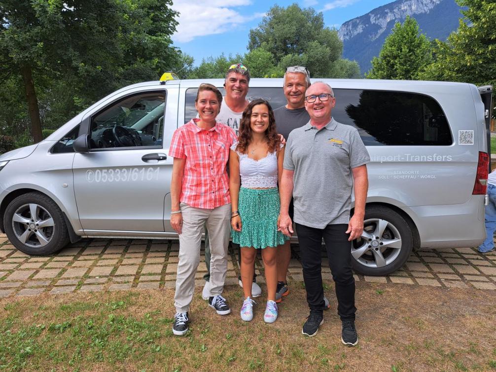 5 Personen vor einem Taxibus